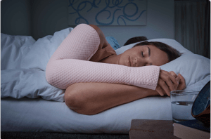 woman sleeping on bed wearing pink compression sleeve