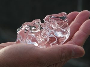 hand holding a misshapen piece of ice
