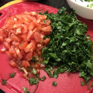 chopped tomato and parsley on a cutting board