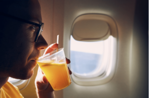 Man drinking juice sitting on airplane