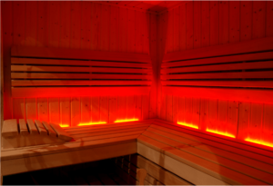 The interior of a wooden suana with red lights.